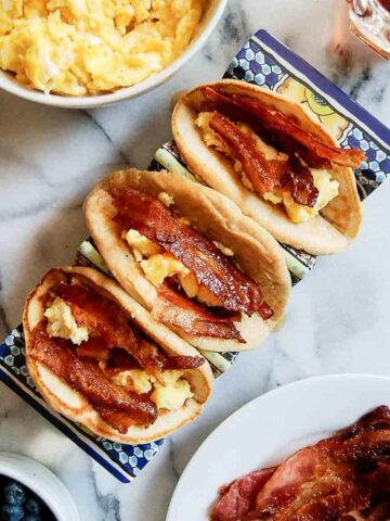 closeup of pancake tacos with bacon and eggs on the countertop.