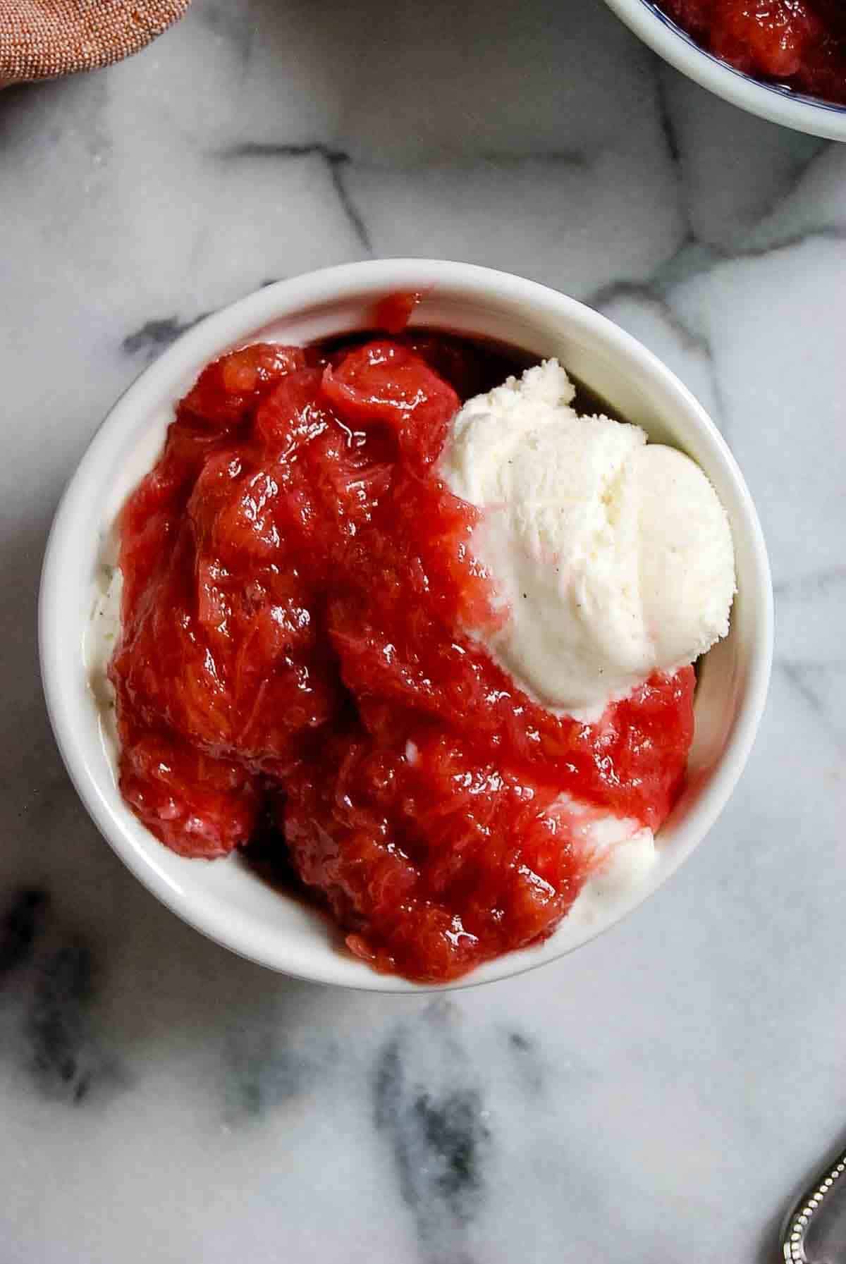 bowl of ice cream with rhubarb sauce over the top.