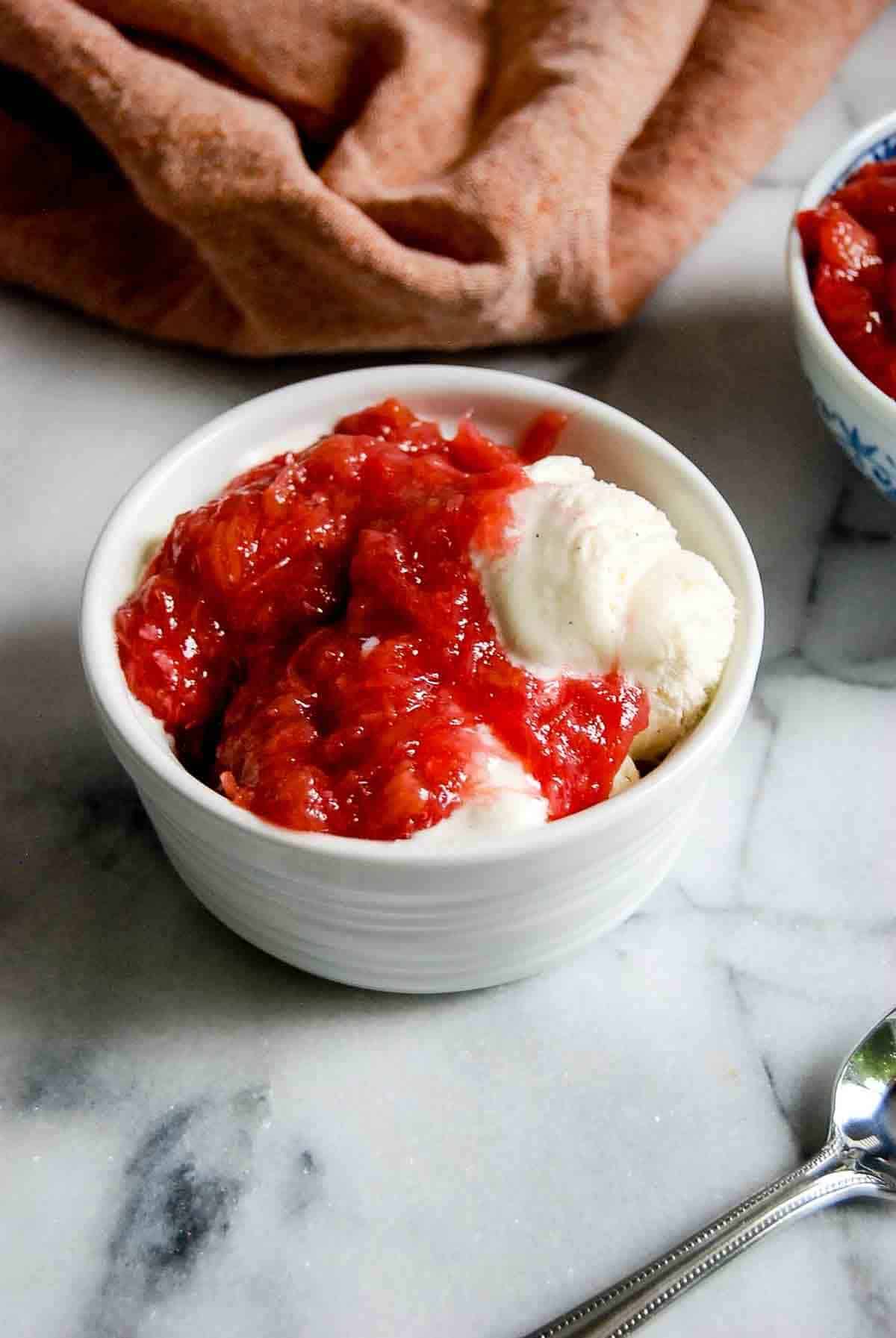 bowl of ice cream with rhubarb sauce on top.