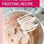 strawberry whipped cream frosting in bowl with beaters on the side.