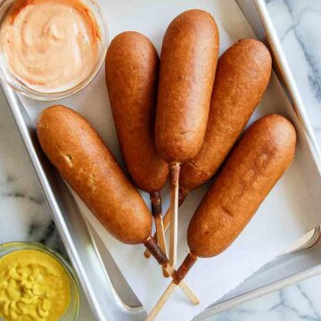 air fryer corn dogs on tray with dipping sauces.