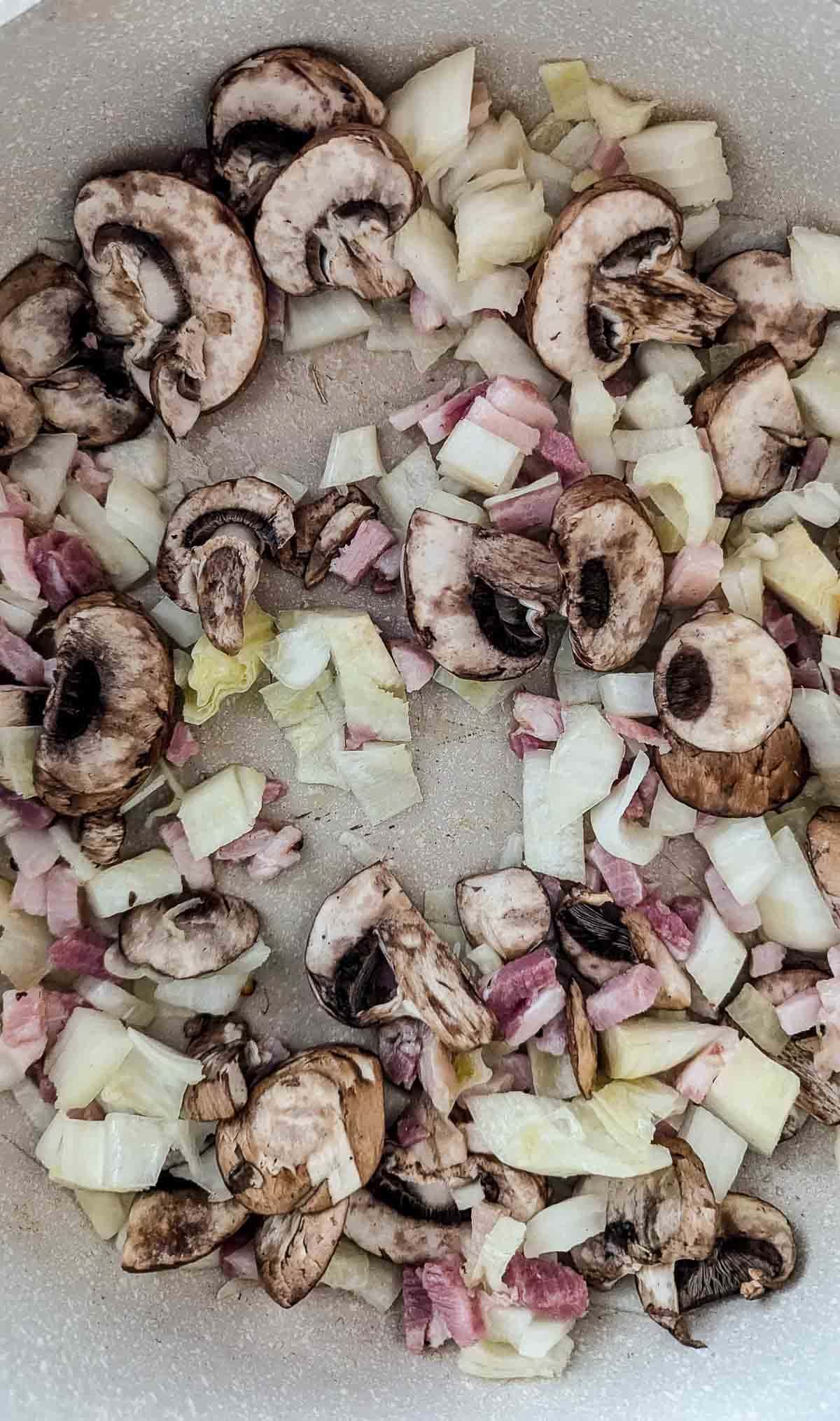 mushrooms, onions and pancetta sautéing in saucepan.