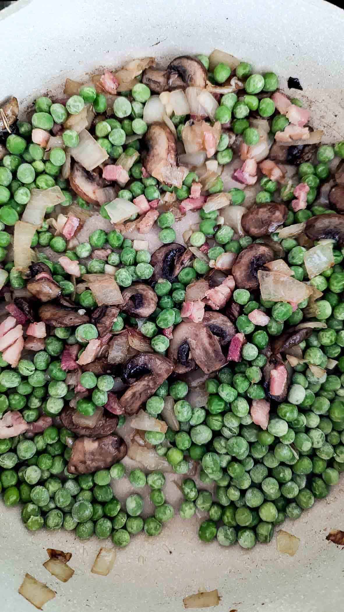 mushrooms, onions, pancetta and peas in saucepan.