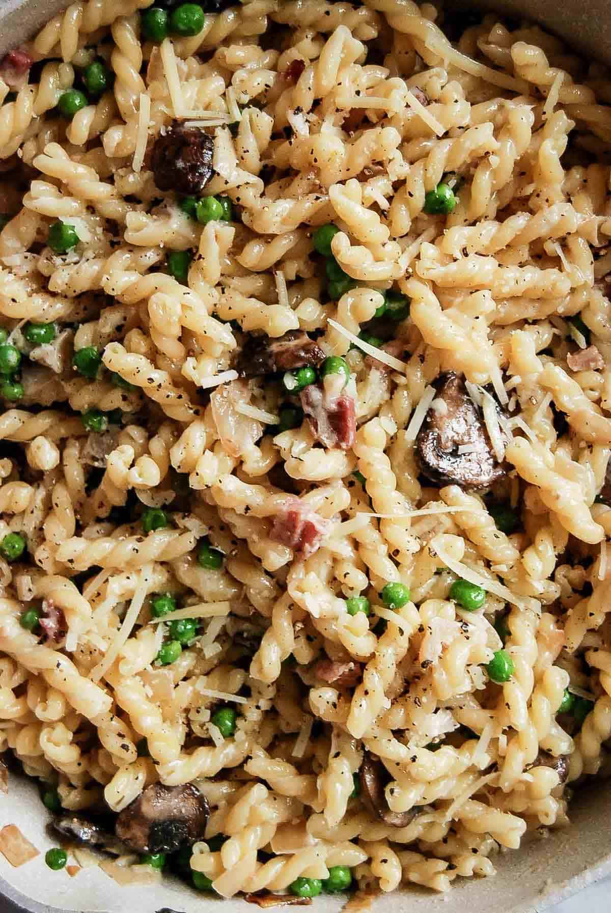 pasta with peas and pancetta in pan.