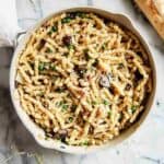 pasta with peas and pancetta in pan with loaf of crusty bread on the side.