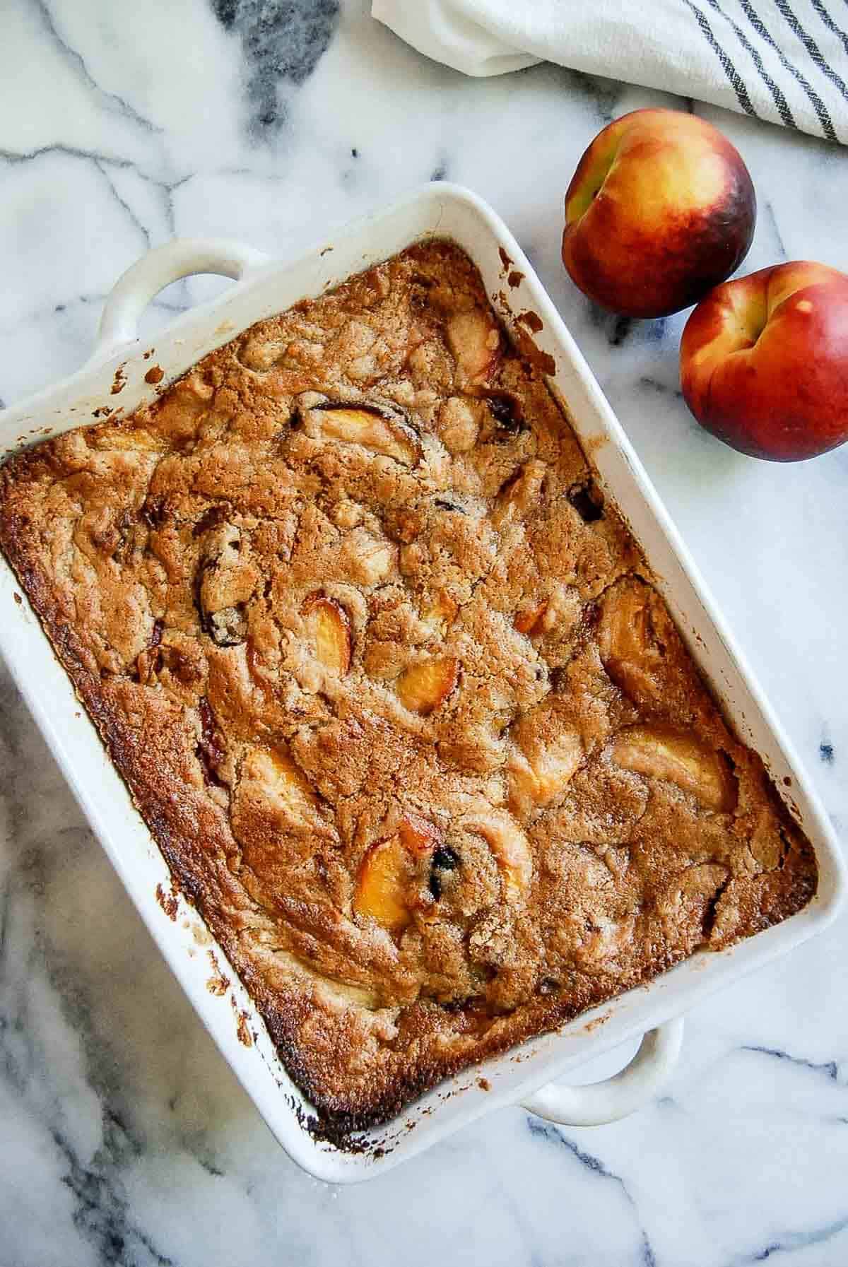 baked peach cobbler (made with cake mix) in casserole dish on countertop.