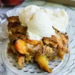 peach cobbler made with cake mix, on plate with a scoop of vanilla ice cream.