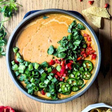 smoked queso dip with garnish on the top.