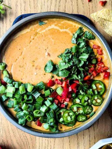 smoked queso dip with garnish on the top.