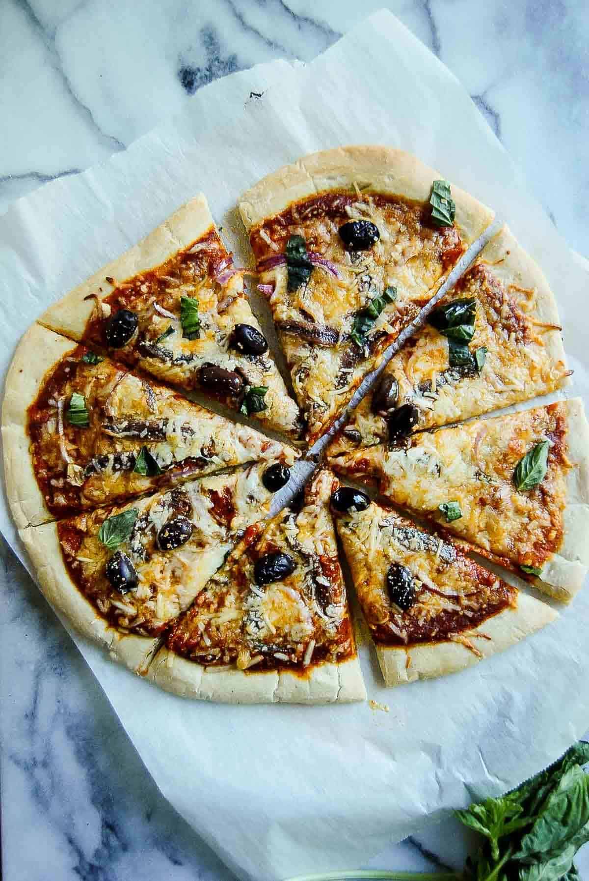 sliced anchovy pizza on countertop.