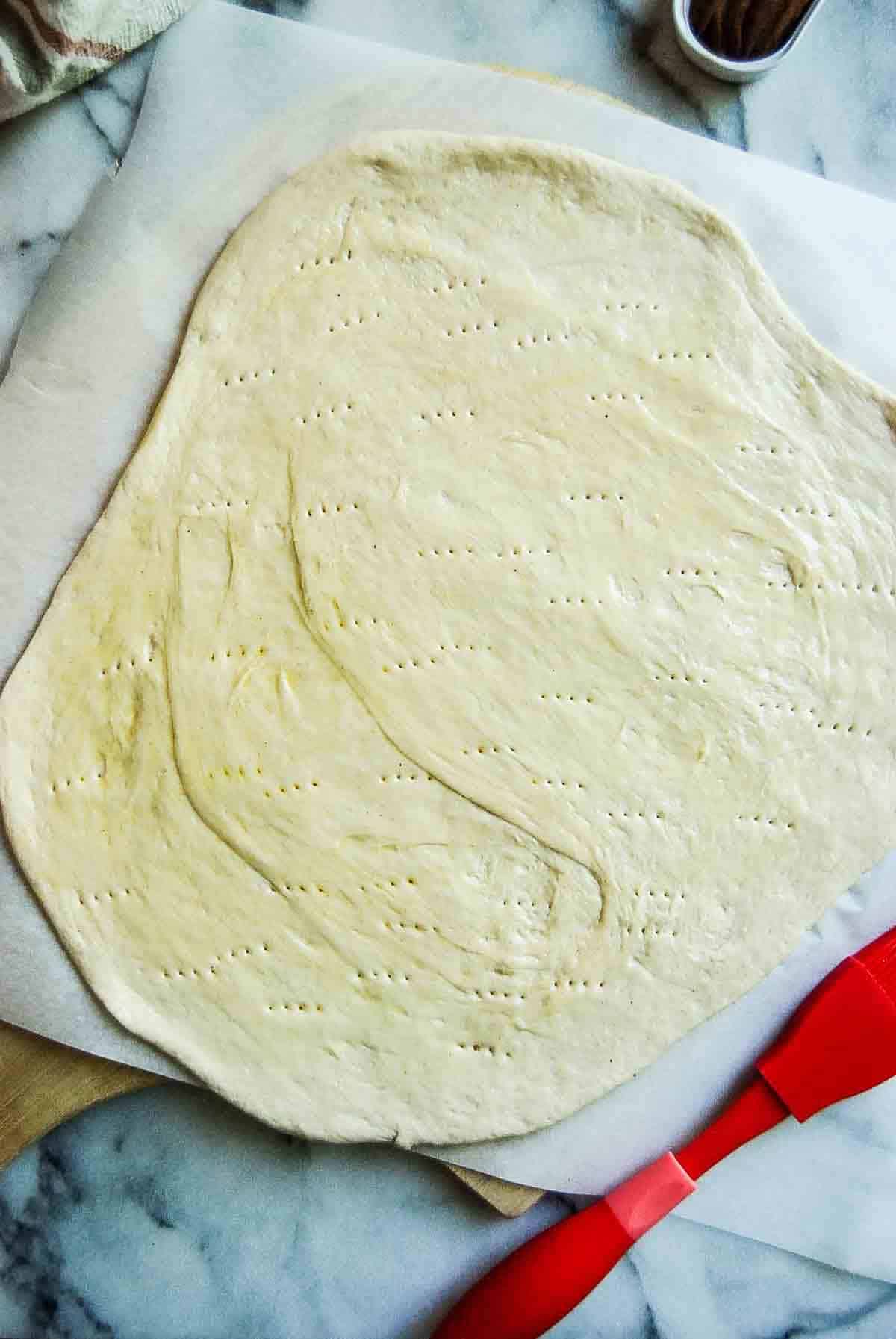 pizza dough, rolled out, oiled and pricked with a fork.