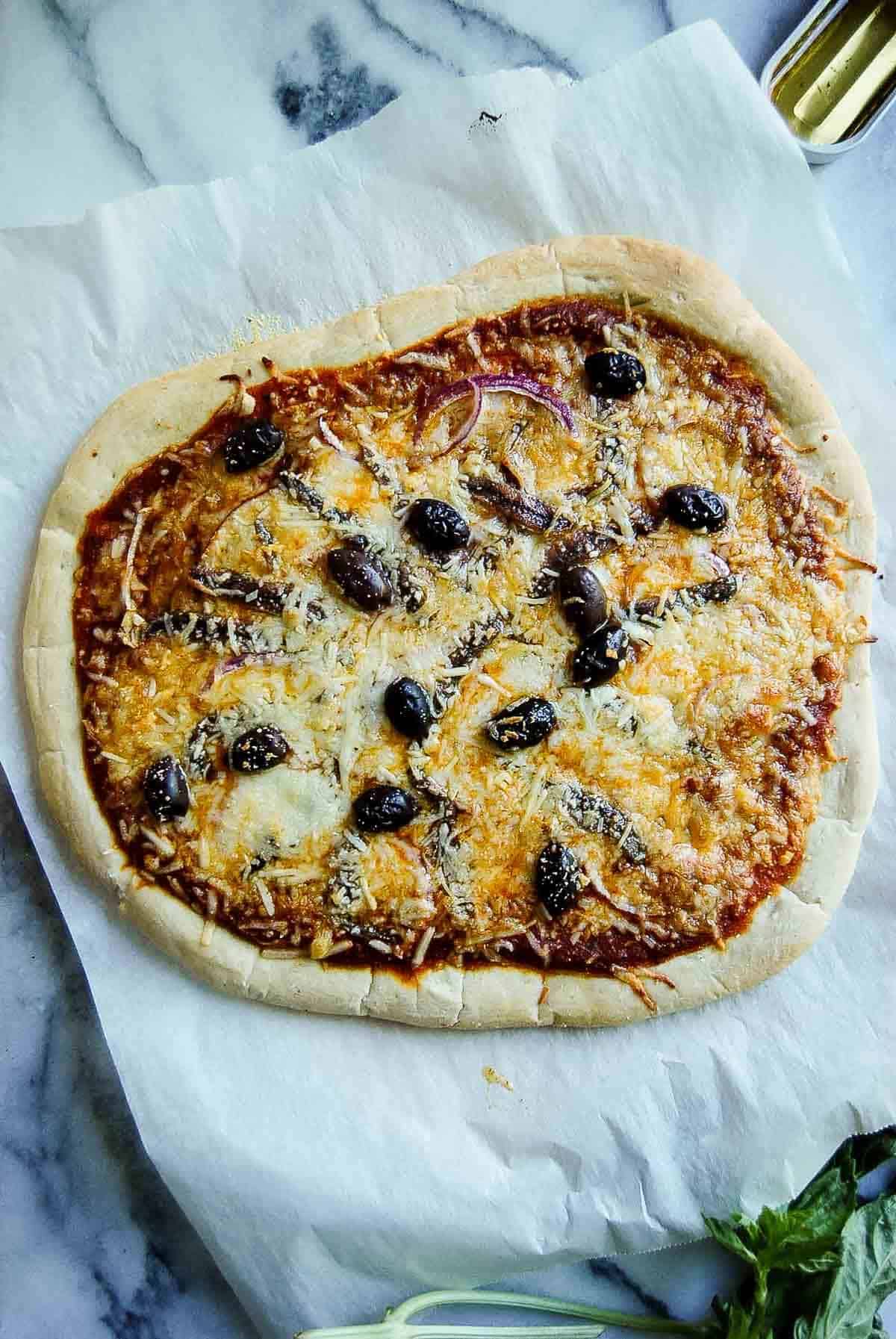 baked anchovy pizza with kalamata olives, red onion and garlic.