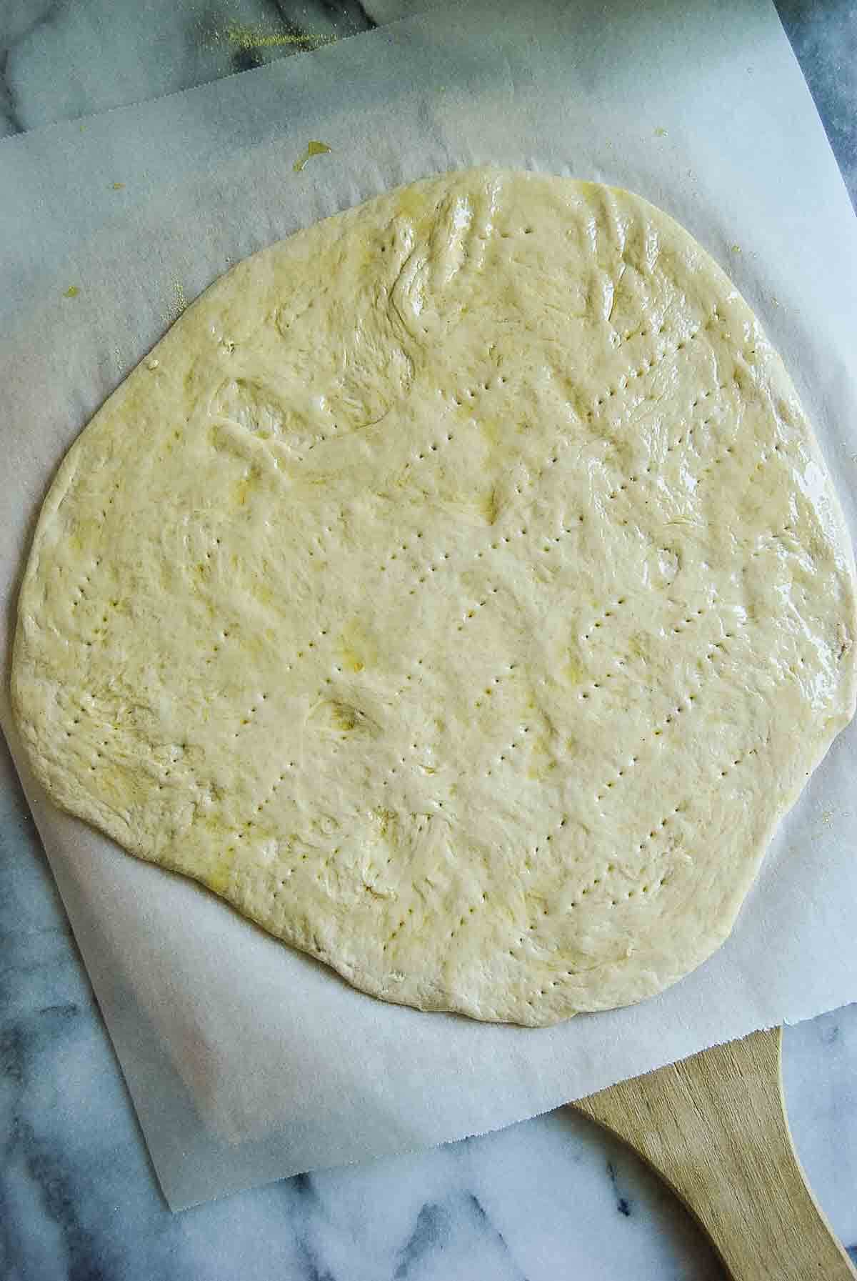 flatbread dough, rolled out and pricked with a fork.