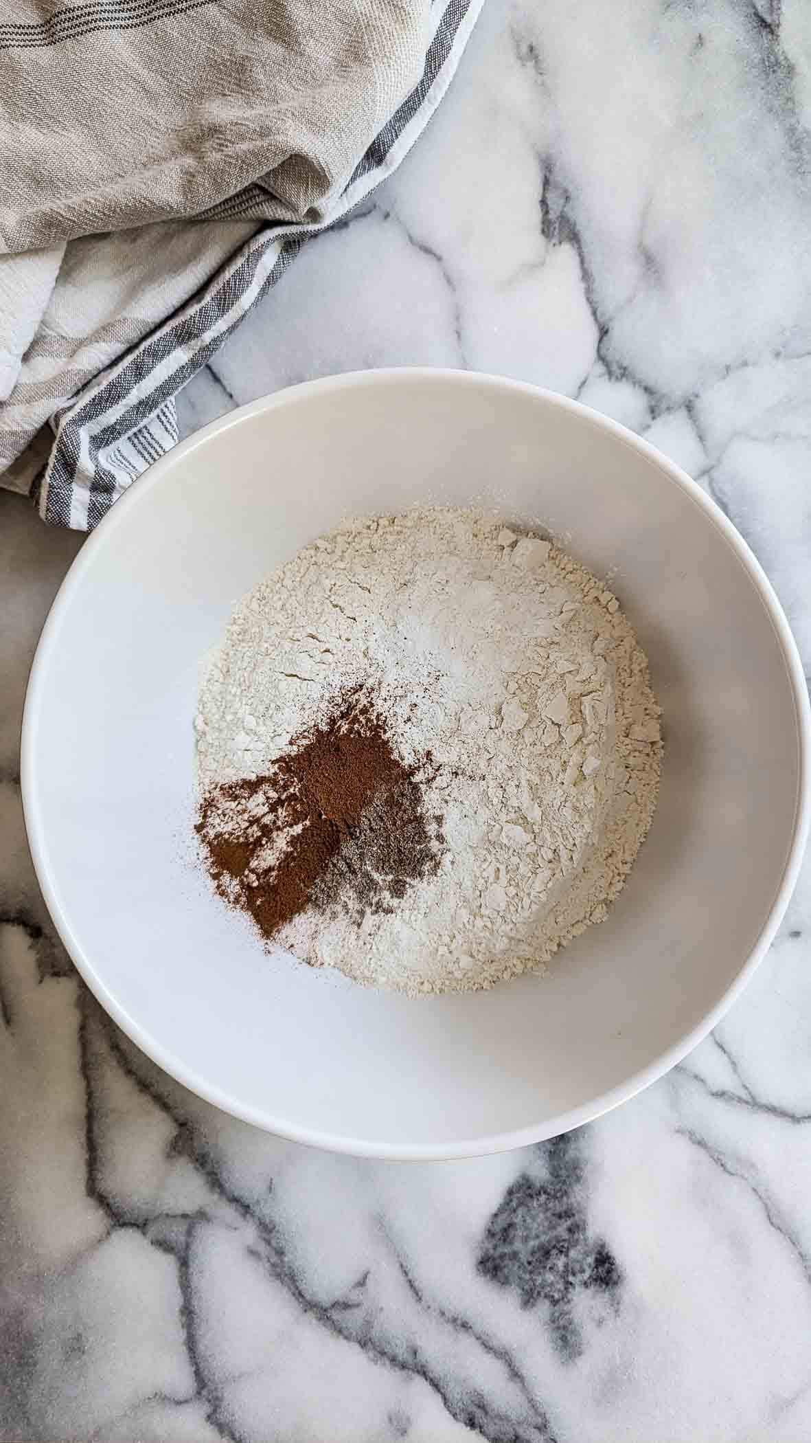 dry ingredients for carrot zucchini muffins in bowl on countertop.