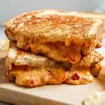 closeup of grilled pimento cheese sandwich on cutting board.
