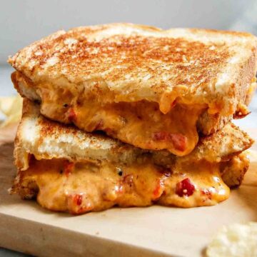 closeup of grilled pimento cheese sandwich on cutting board.