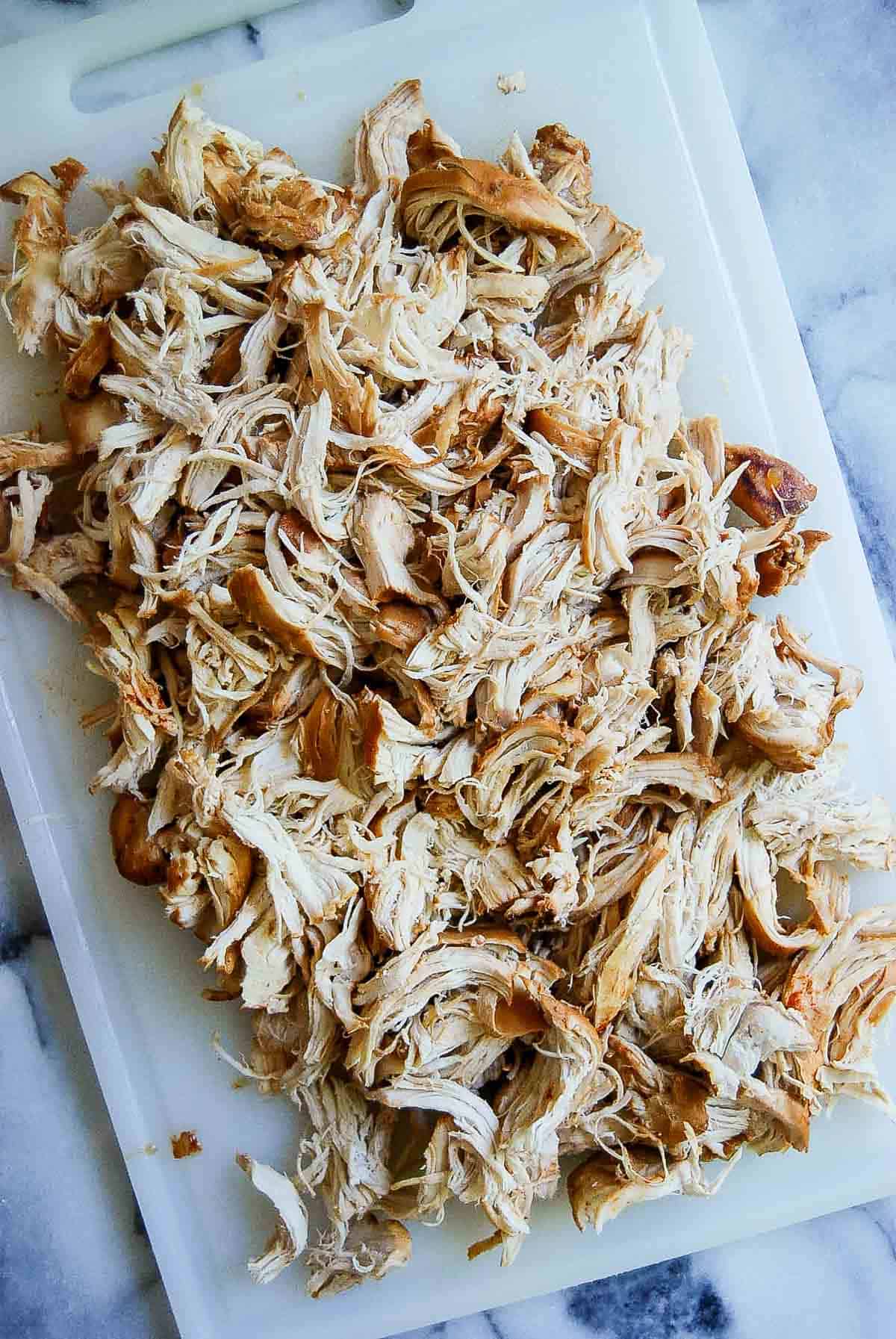 shredded instant pot bbq chicken on cutting board.
