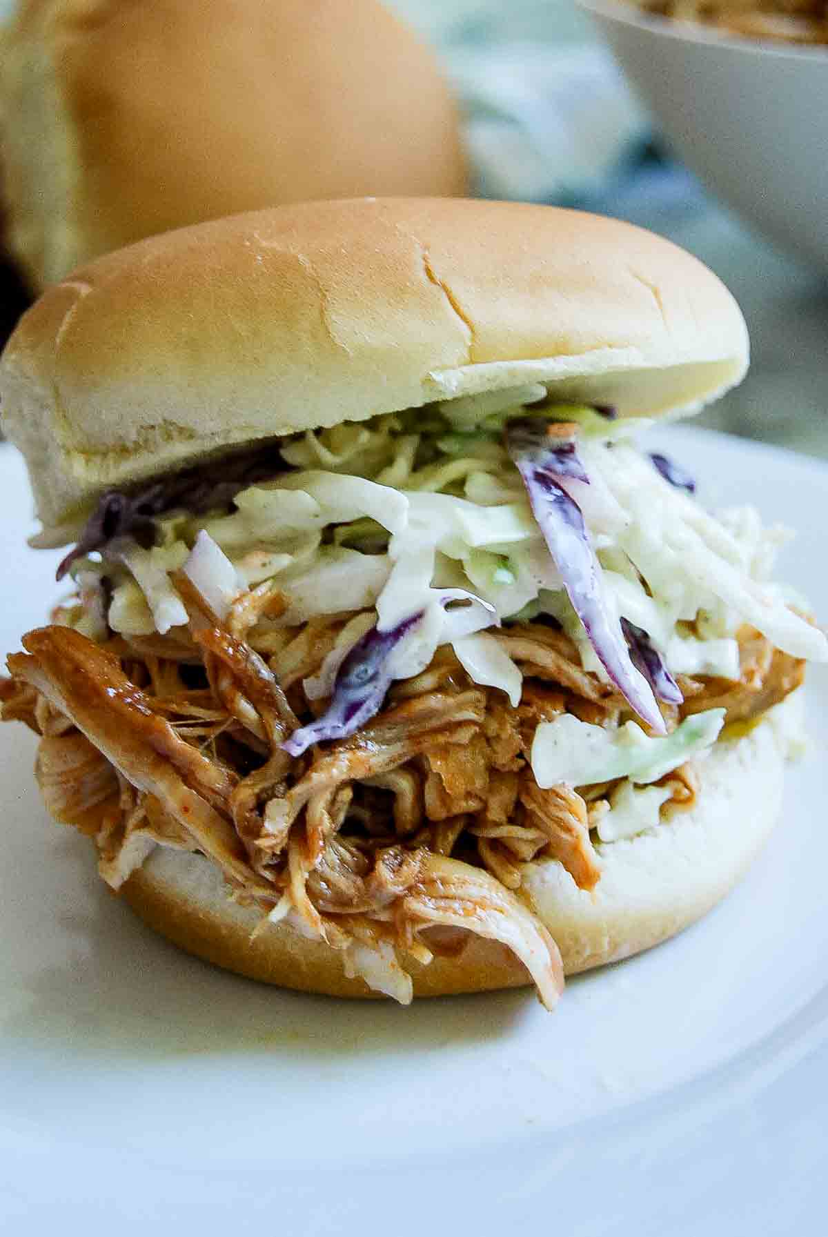 instant pot barbecue chicken on sandwich bun with coleslaw.