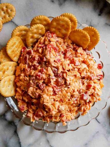 old fashioned pimento cheese dip in bowl with crackers on the side.
