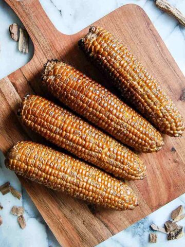 smoked corn on the cob on cutting board.