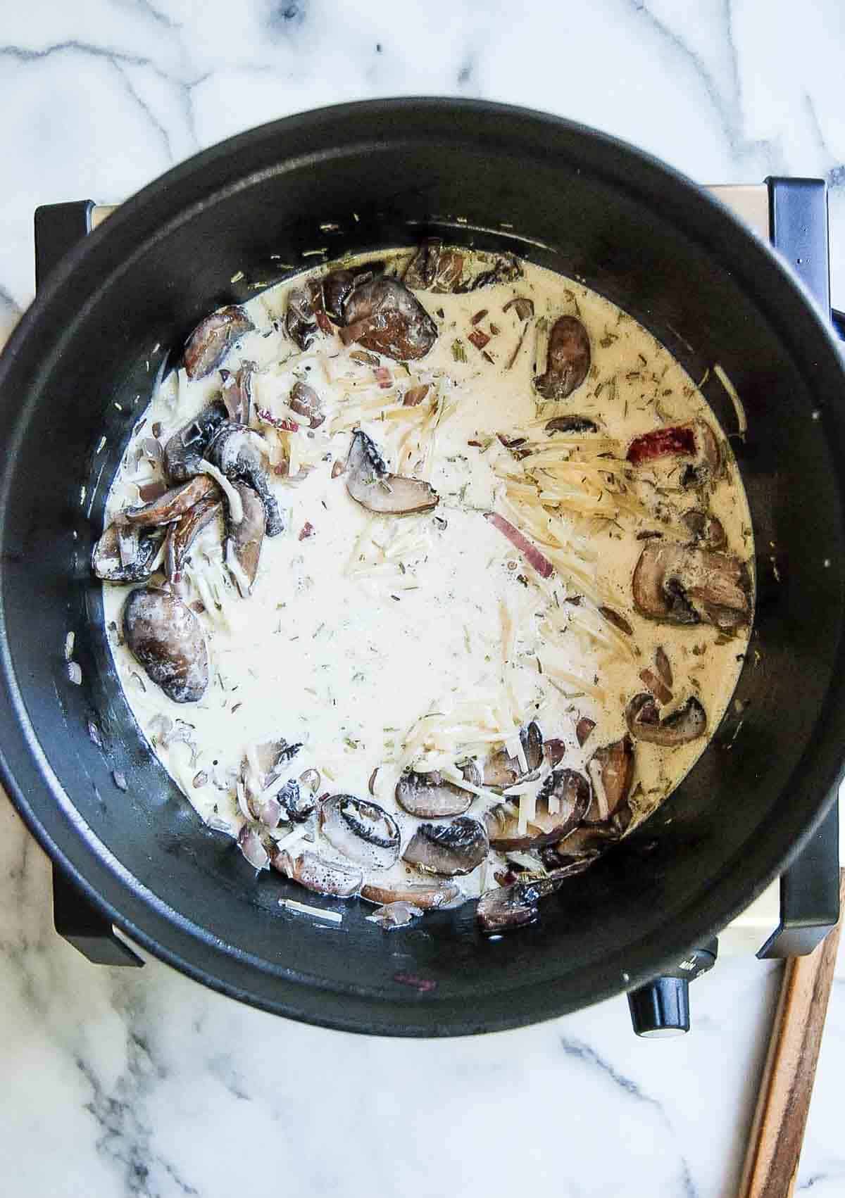 creamy mushroom sauce for black truffle pasta in pot.