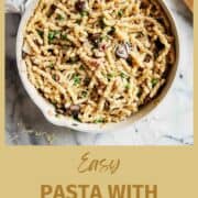 pasta with pancetta and peas on countertop.
