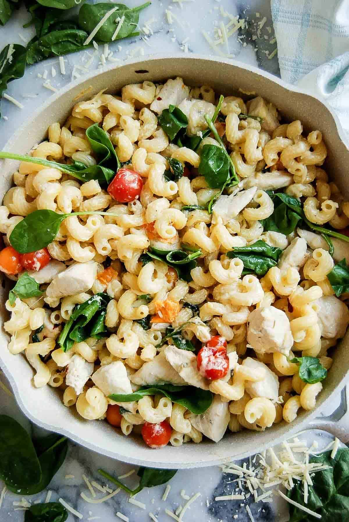 pot of Boursin cheese pasta with chicken and tomatoes on countertop.