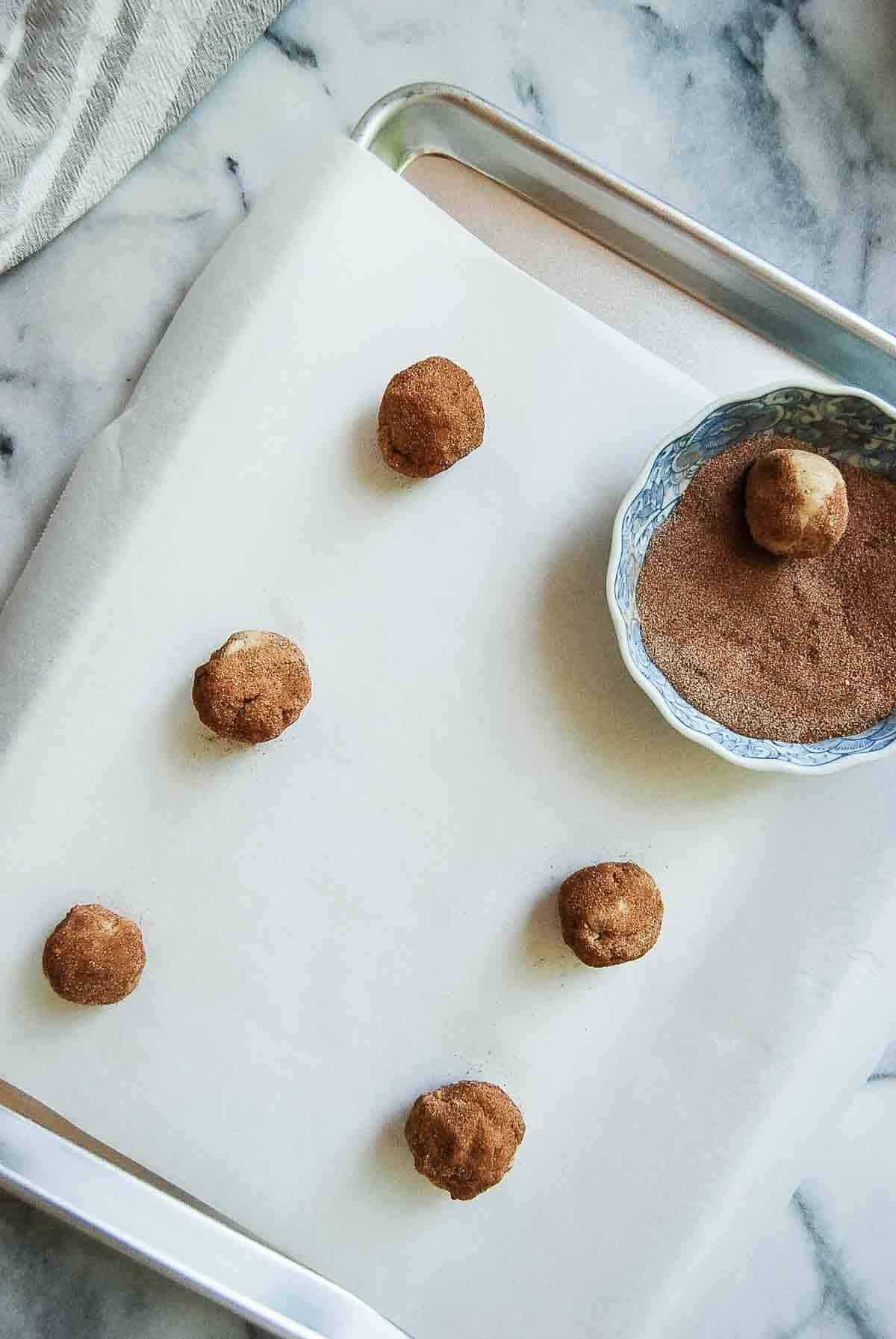 snickerdoodle balls, rolled in cinnamon sugar and placed on baking sheet.