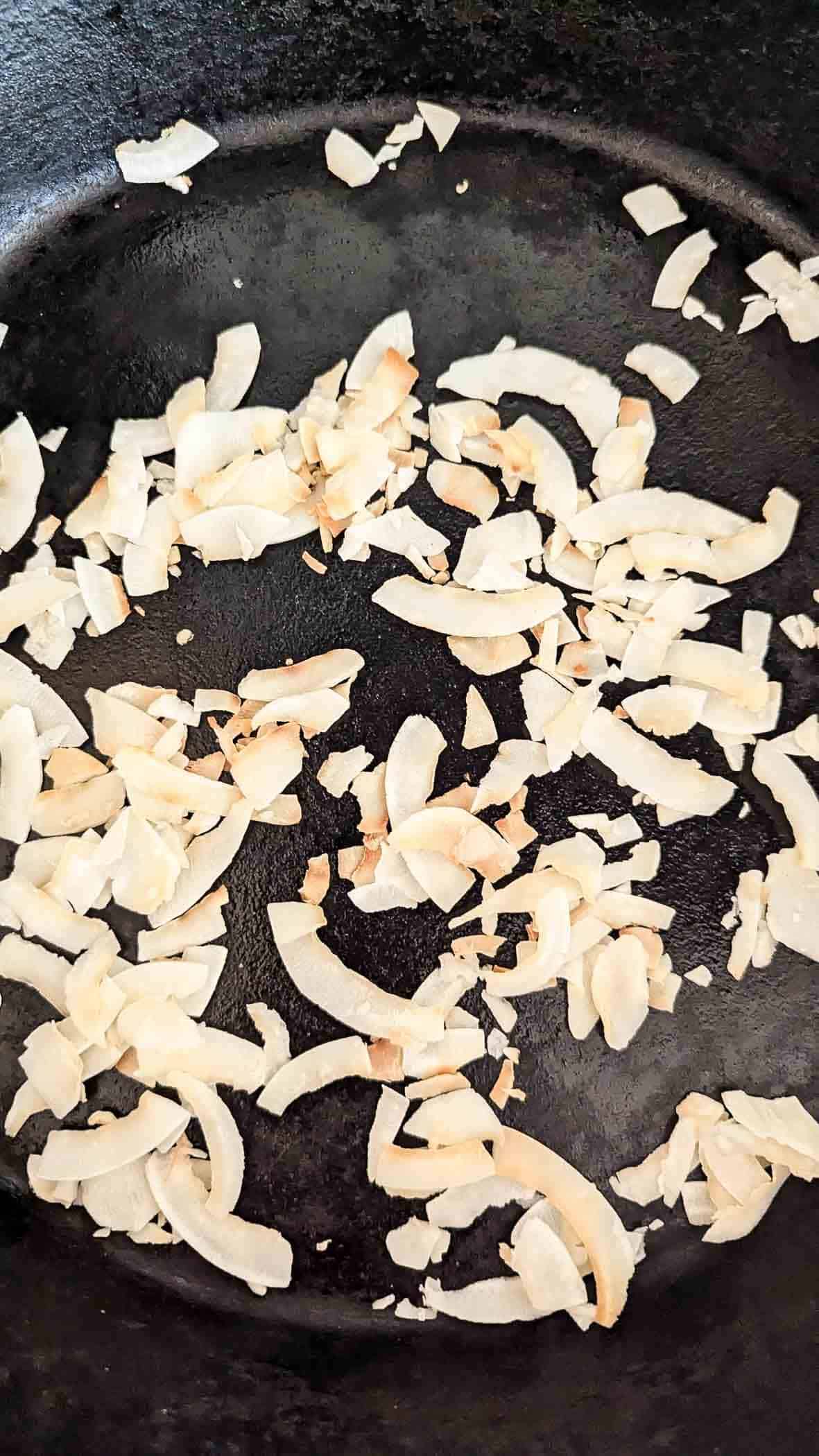 coconut flakes toasting in pan.