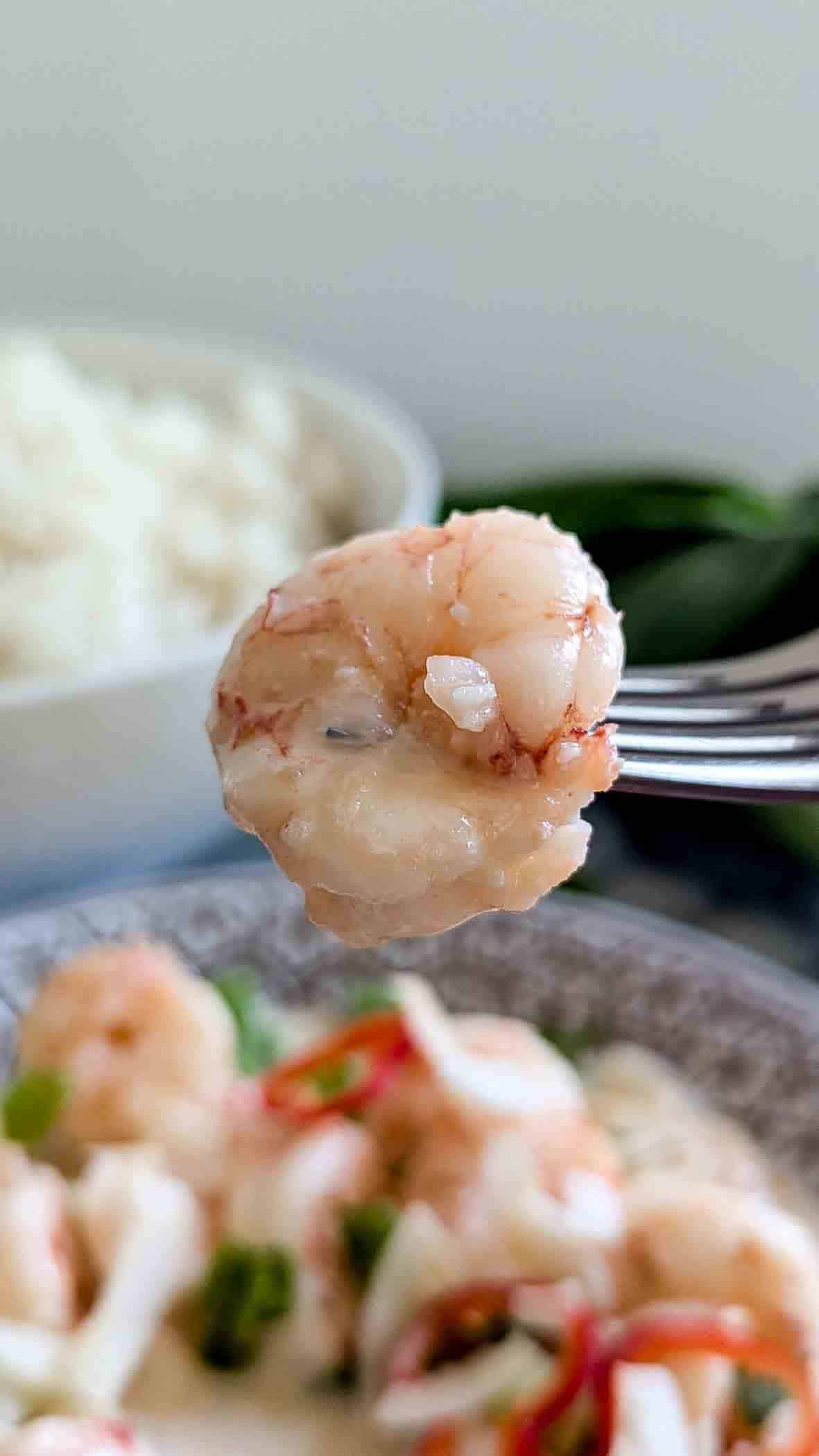 fork holding pice of Chinese coconut shrimp.