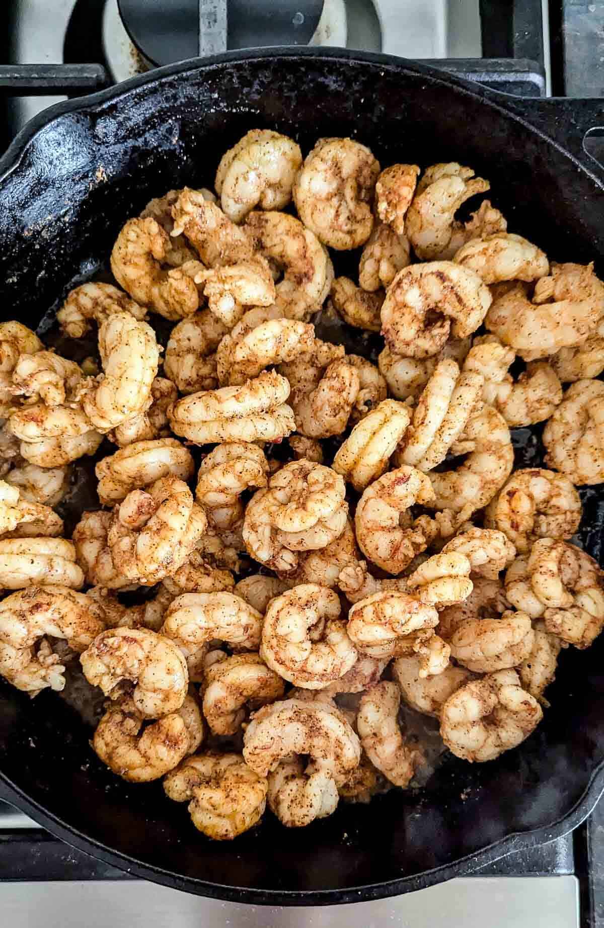 baja seasoned shrimp sautéing in skillet.
