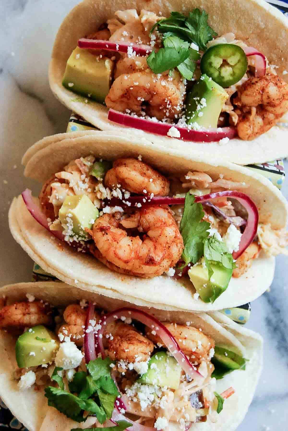 loaded baja shrimp tacos with avocado, pickled onions and cilantro.