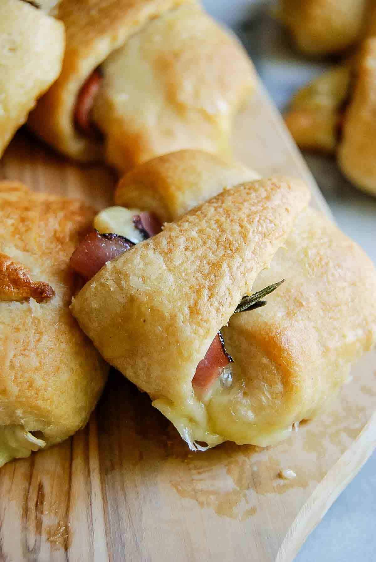 side view of ham and cheese crescent roll with honey and rosemary.