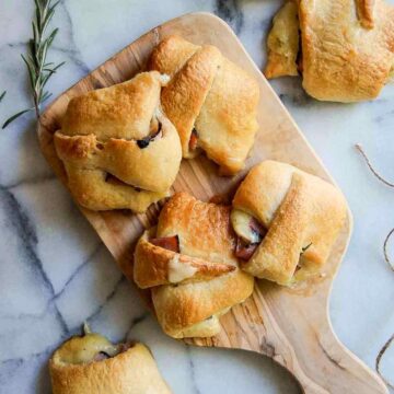 baked ham and cheese crescent roll sandwiches on cutting board.