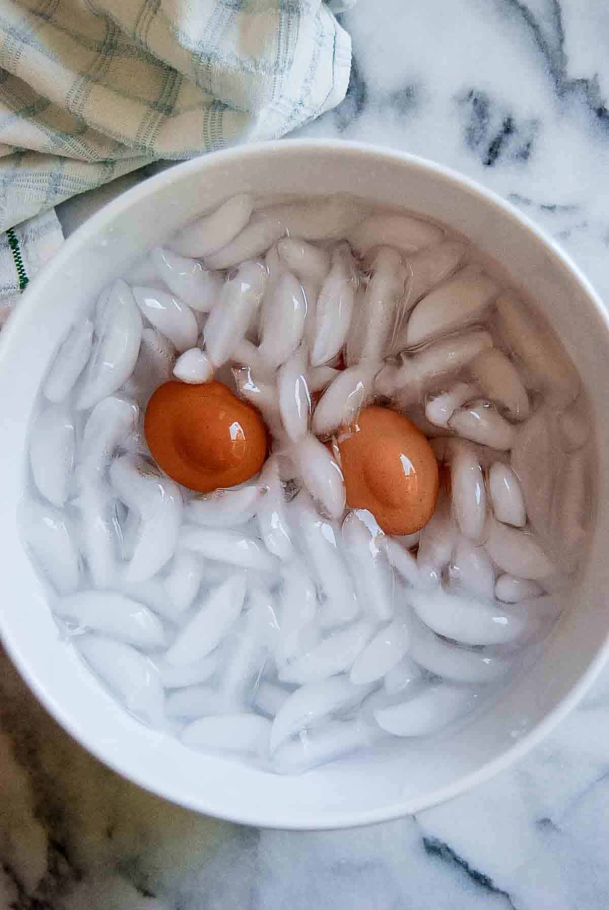 soft boiled eggs in ice bath on countertop.