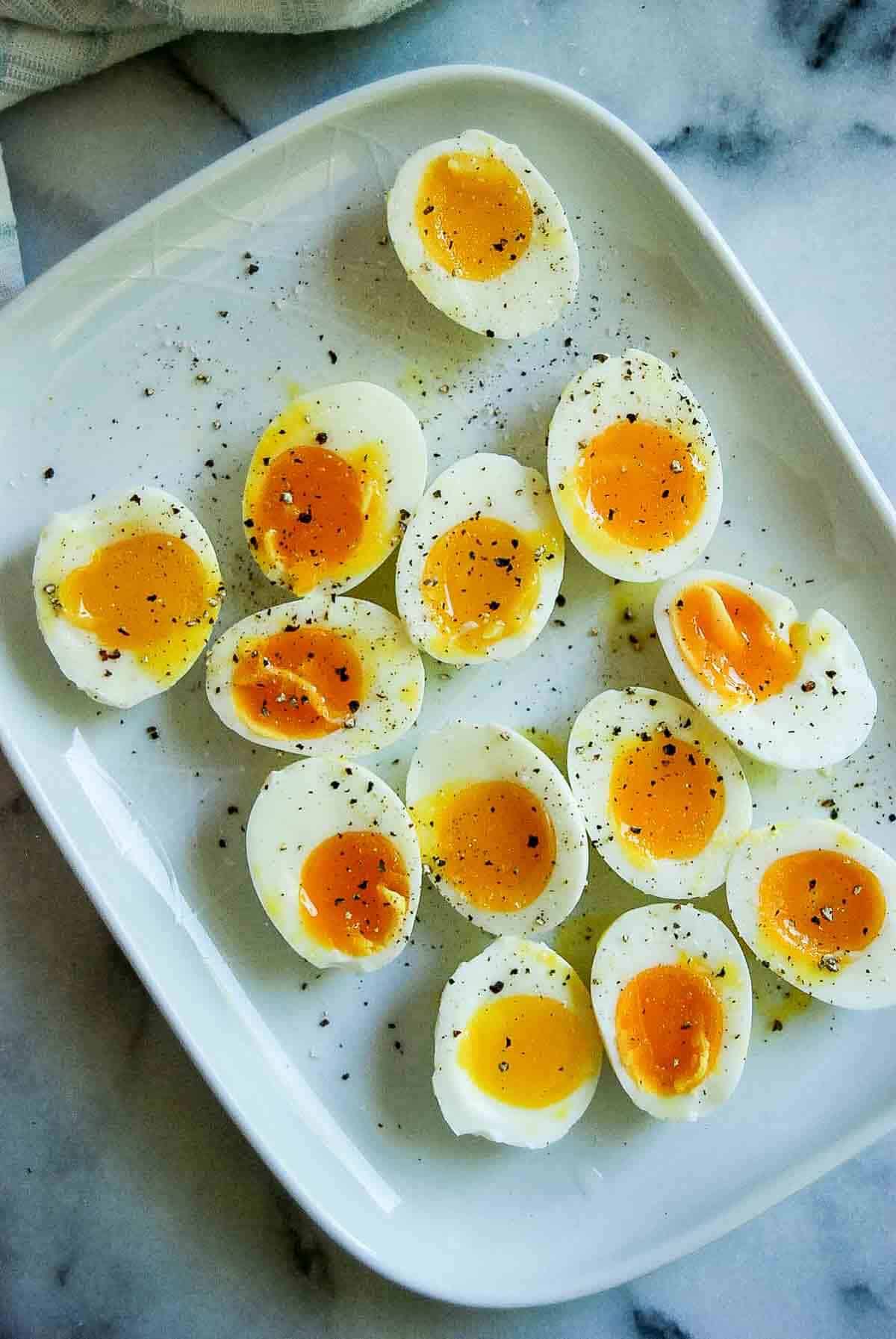 perfect jammy eggs on plate sprinkled with salt and pepper.
