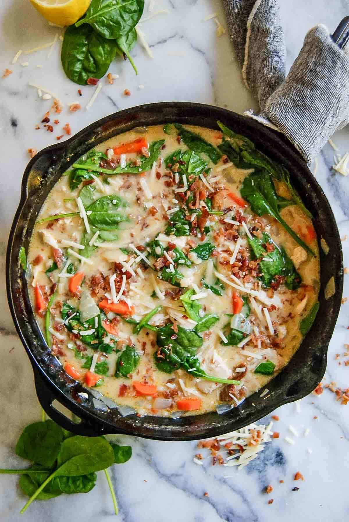 chicken and spinach soup in pot on countertop.