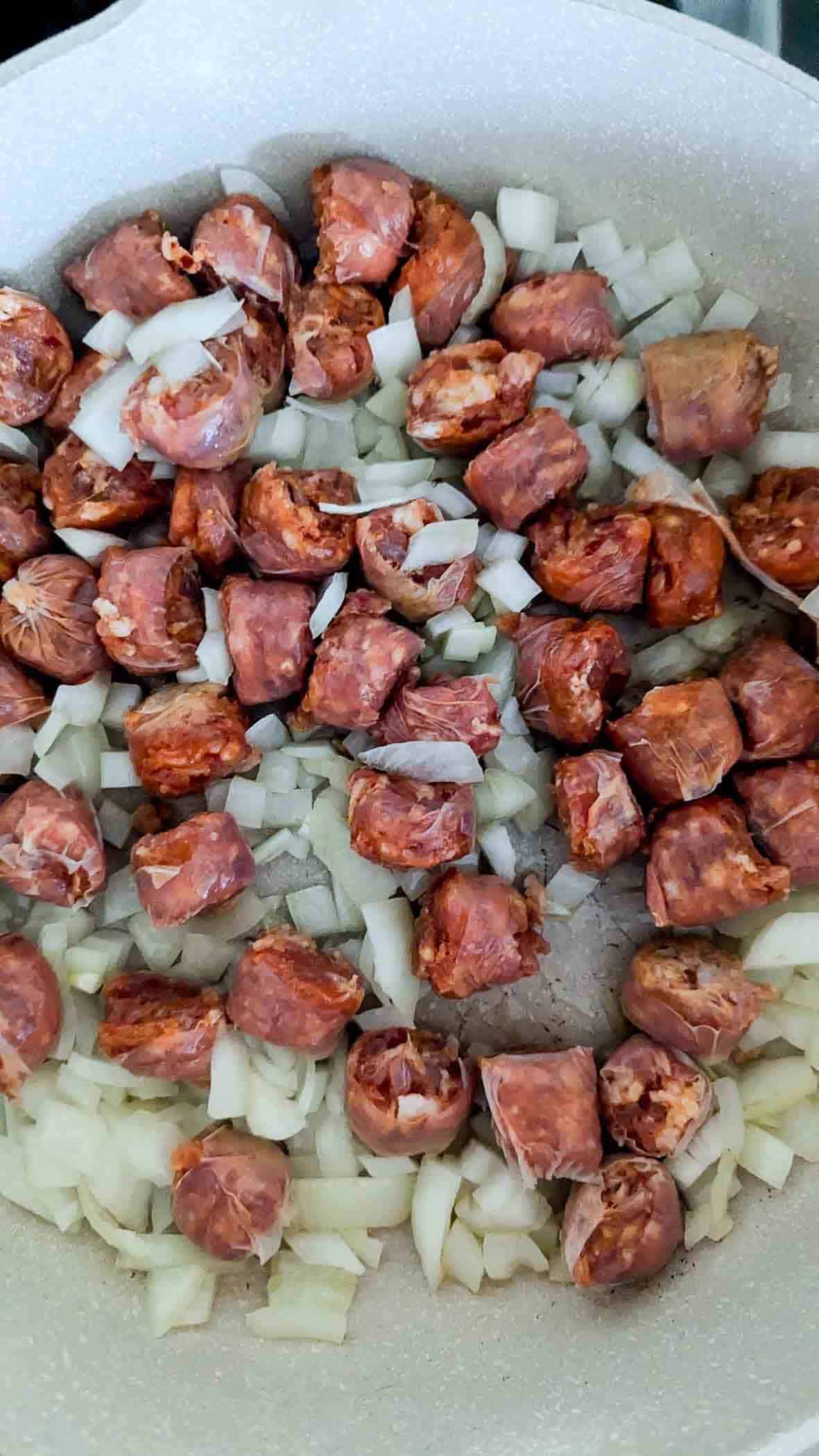sausage and onions cooking in pot.