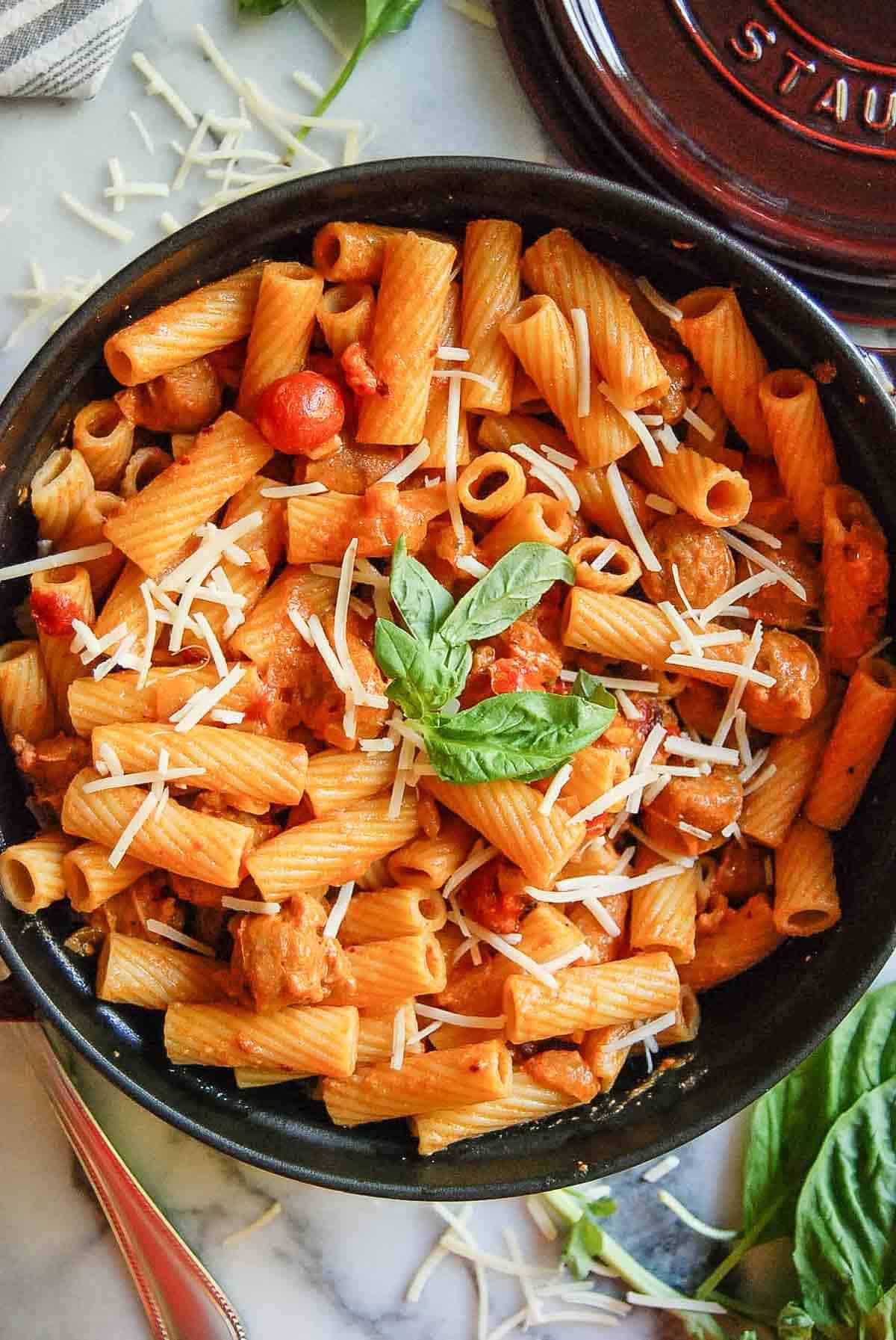 spicy rigatoni vodka pasta with sausage in pot on countertop.
