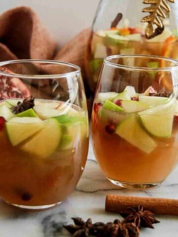 side view of thanksgiving sangria in glasses with cinnamon stick and star anise on the side.