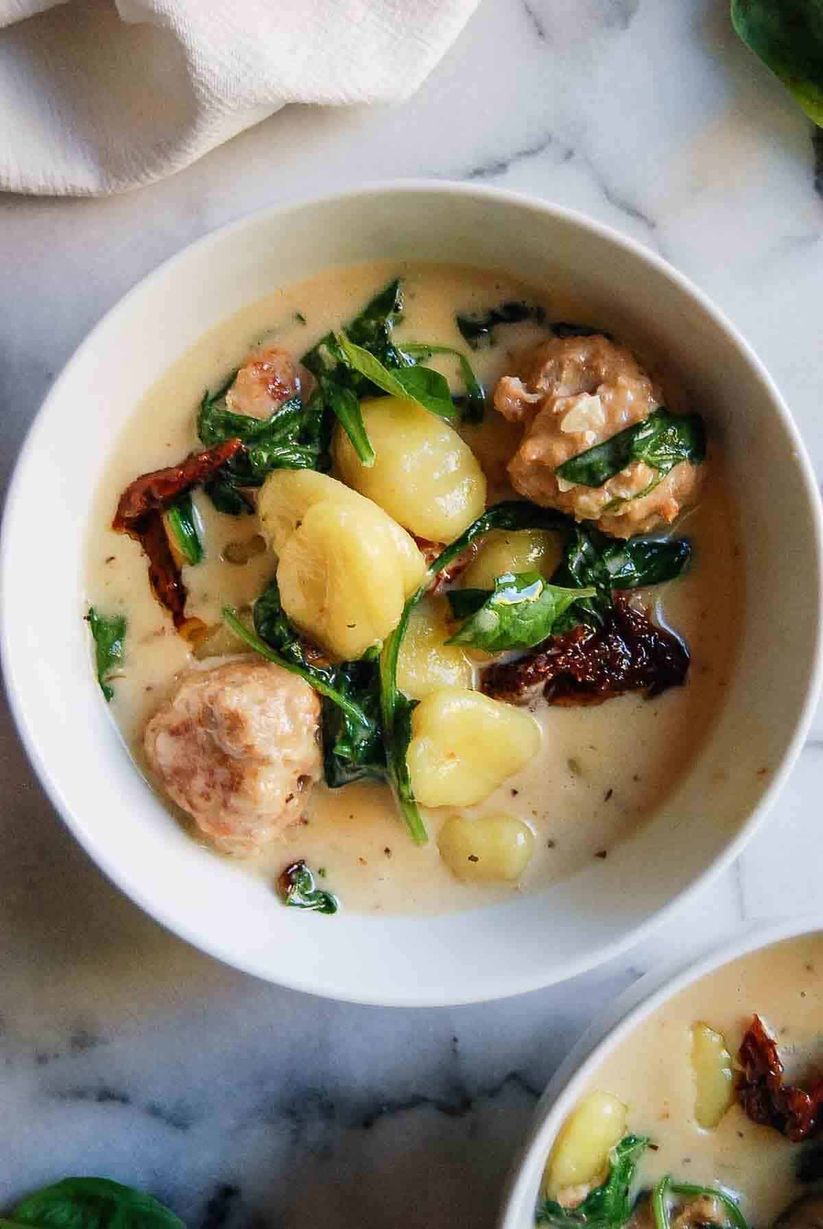 closeup of bowl full of chicken meatballs and gnocchi mixture.
