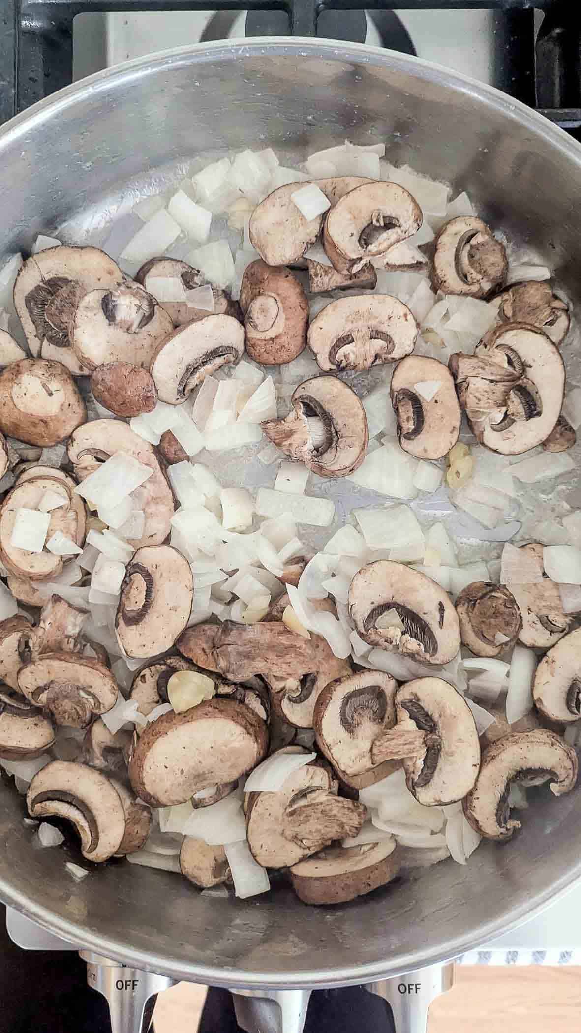 mushrooms and onions sautéing in pan.