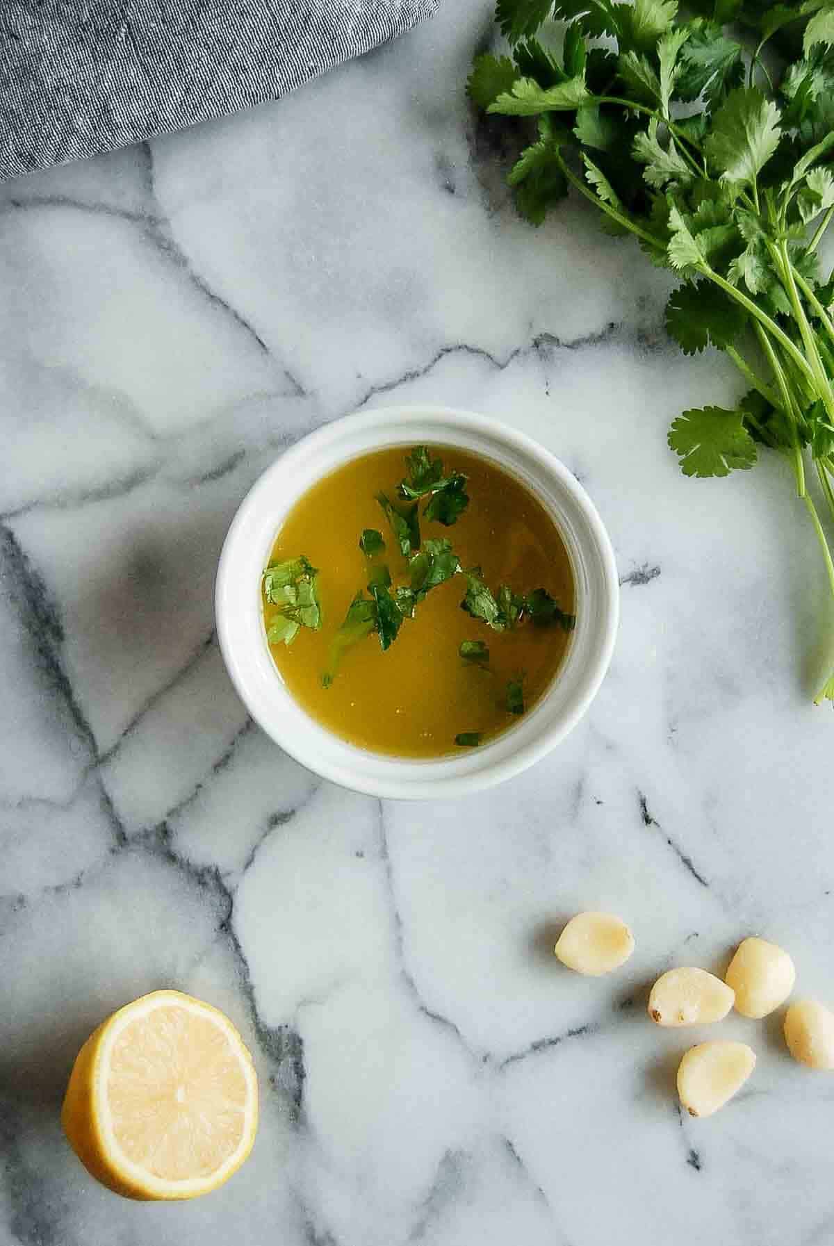 garlic, lemon butter sauce with parsley ingredients on countertop.