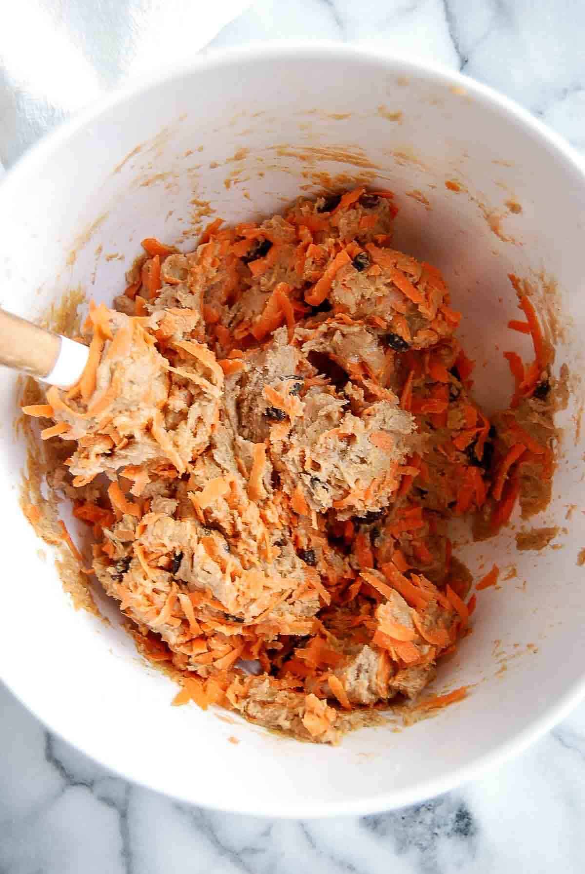 carrot cake cookie dough with shredded carrots and raisins.