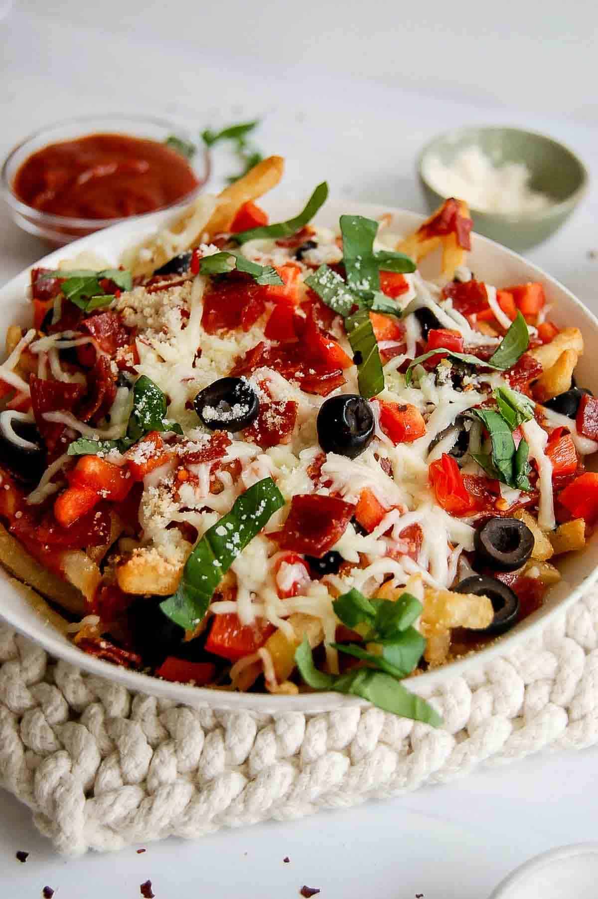 Loaded pizza fries with pepperoni, red pepper, black olives, mozzarella, and basil.