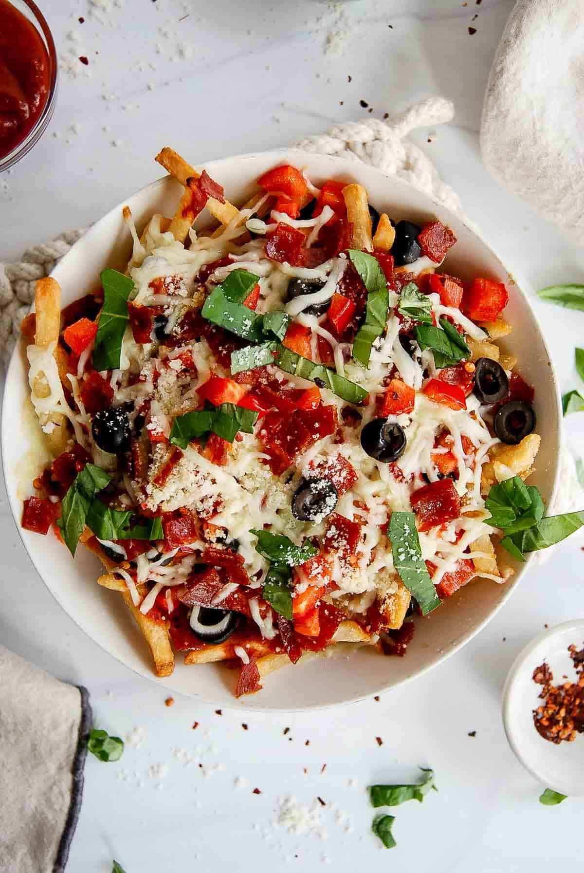 Loaded pizza fries with pepperoni, red pepper, black olives, mozzarella, and basil.