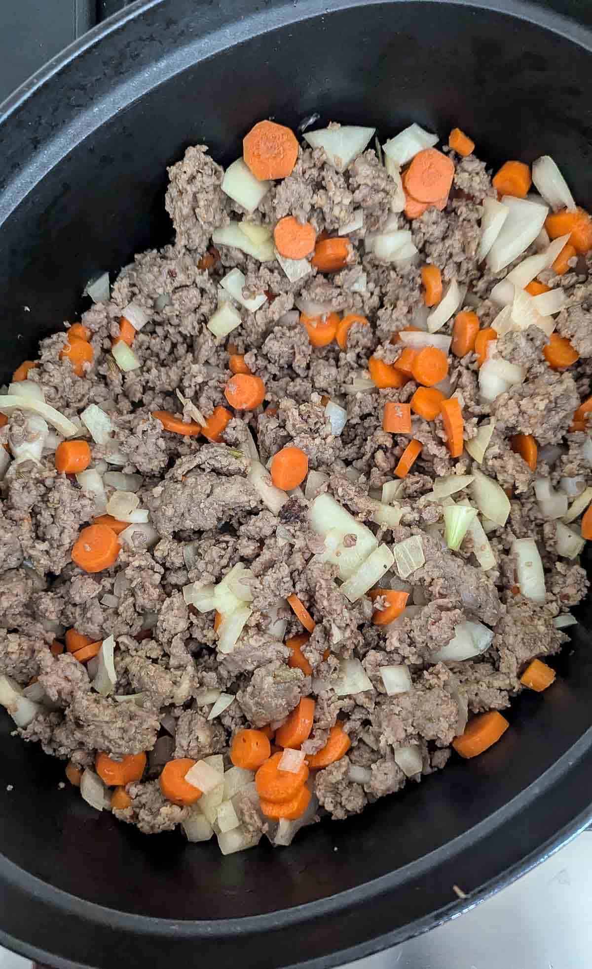 browned sausage with carrots and onions.