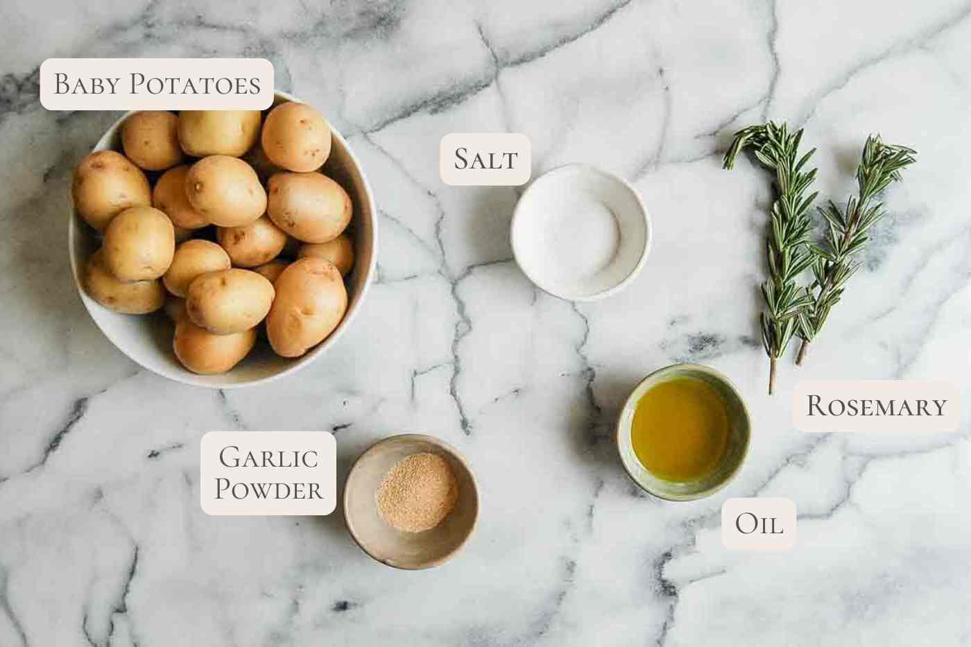 ingredients for baby potatoes with rosemary and garlic on countertop, labeled.