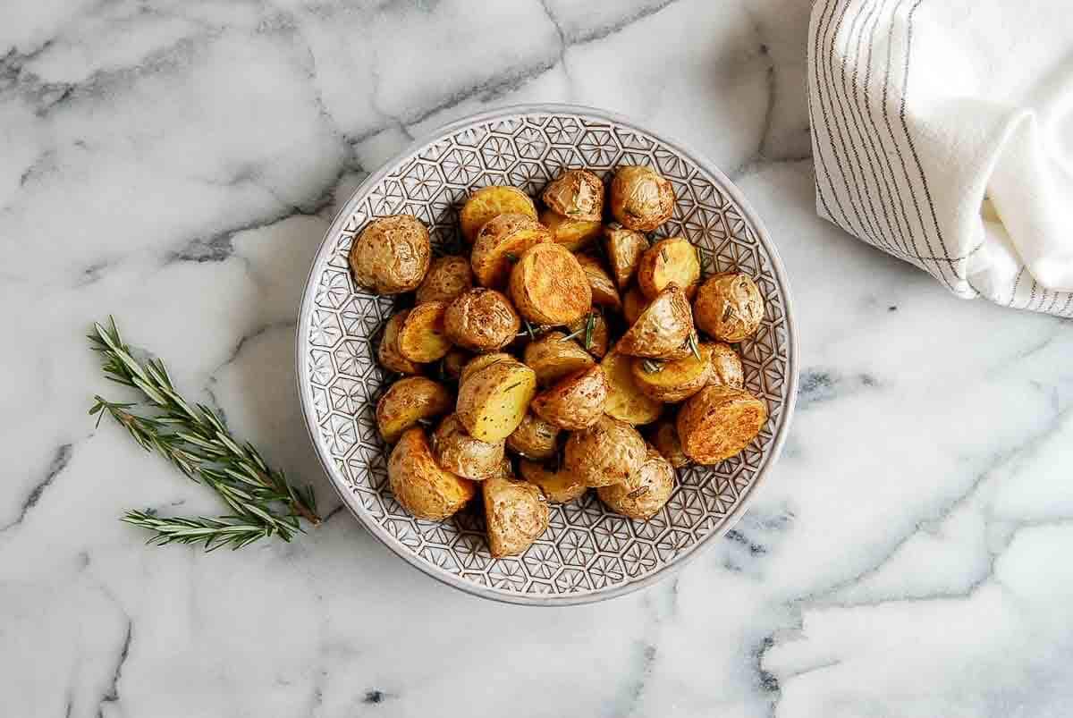roasted baby potatoes with garlic and rosemary in bowl on countertop.