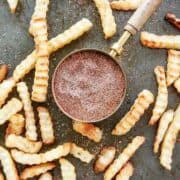 top down view of fry seasoning with seasoned fries scattered around it.